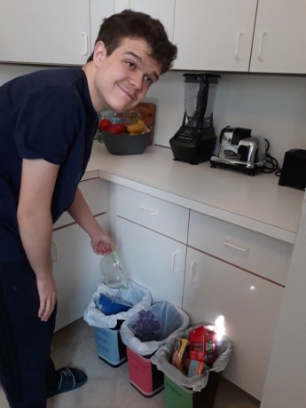 Student separating recycling into bins